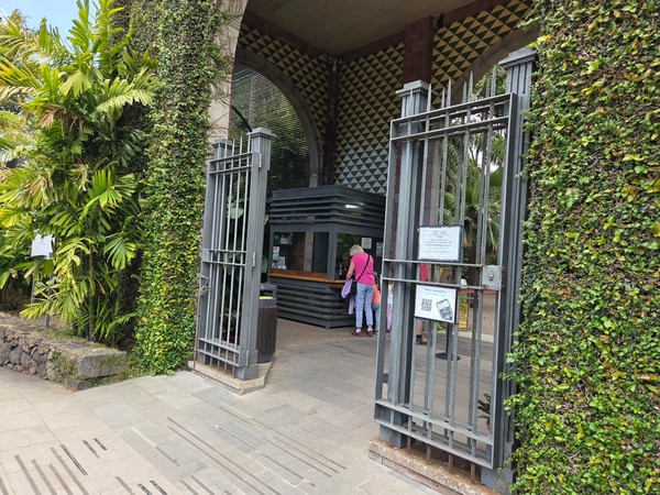 Entrada principal del Jardín Botánico del Puerto de la Cruz con vegetación tropical y visitantes.