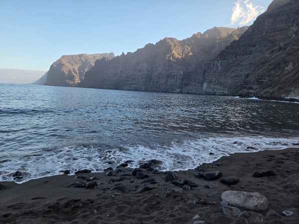 Playa con vistas a los impresionantes acantilados de Los Gigantes en Tenerife al atardecer.