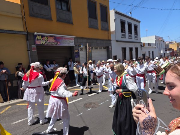 Grupo folclórico y bailarines en la Romería de Tegueste, con trajes típicos canarios y música tradicional.